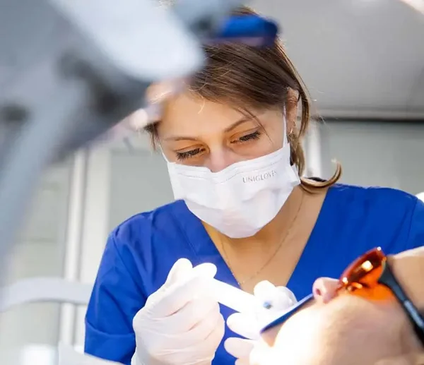 Prophylaxeassistentin tr&auml;gt Bleachinggel bei einem Patienten auf